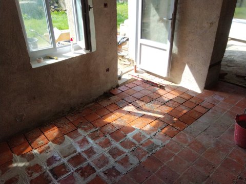 Pose de tomettes rouges dans une longère