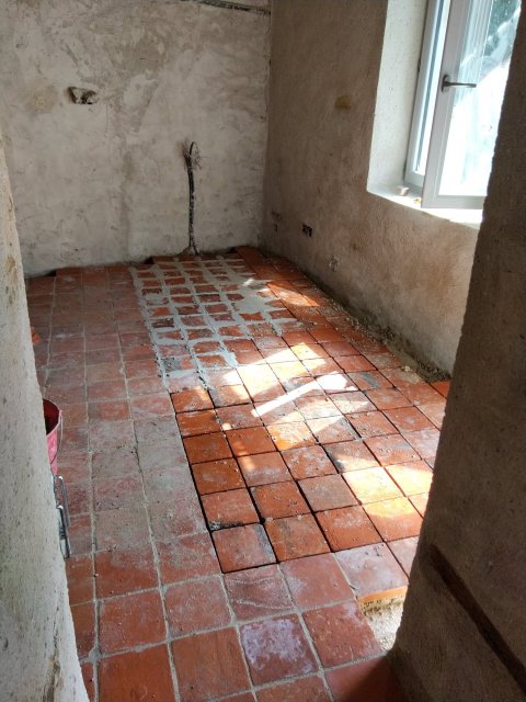 Pose de tomettes rouges dans une longère