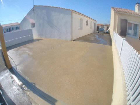Réalisation d’un aménagement extérieur en micro-béton désactivé jaune aux Sables-d’Olonne, avec une finition antidérapante et décorative.